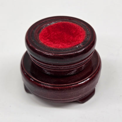 Round wood sphere holder with red velvet on a neutral background