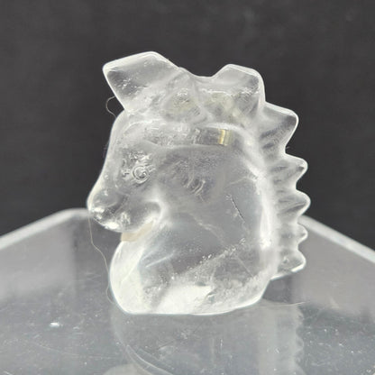 Clear Quartz Unicorn head carving on a dark background