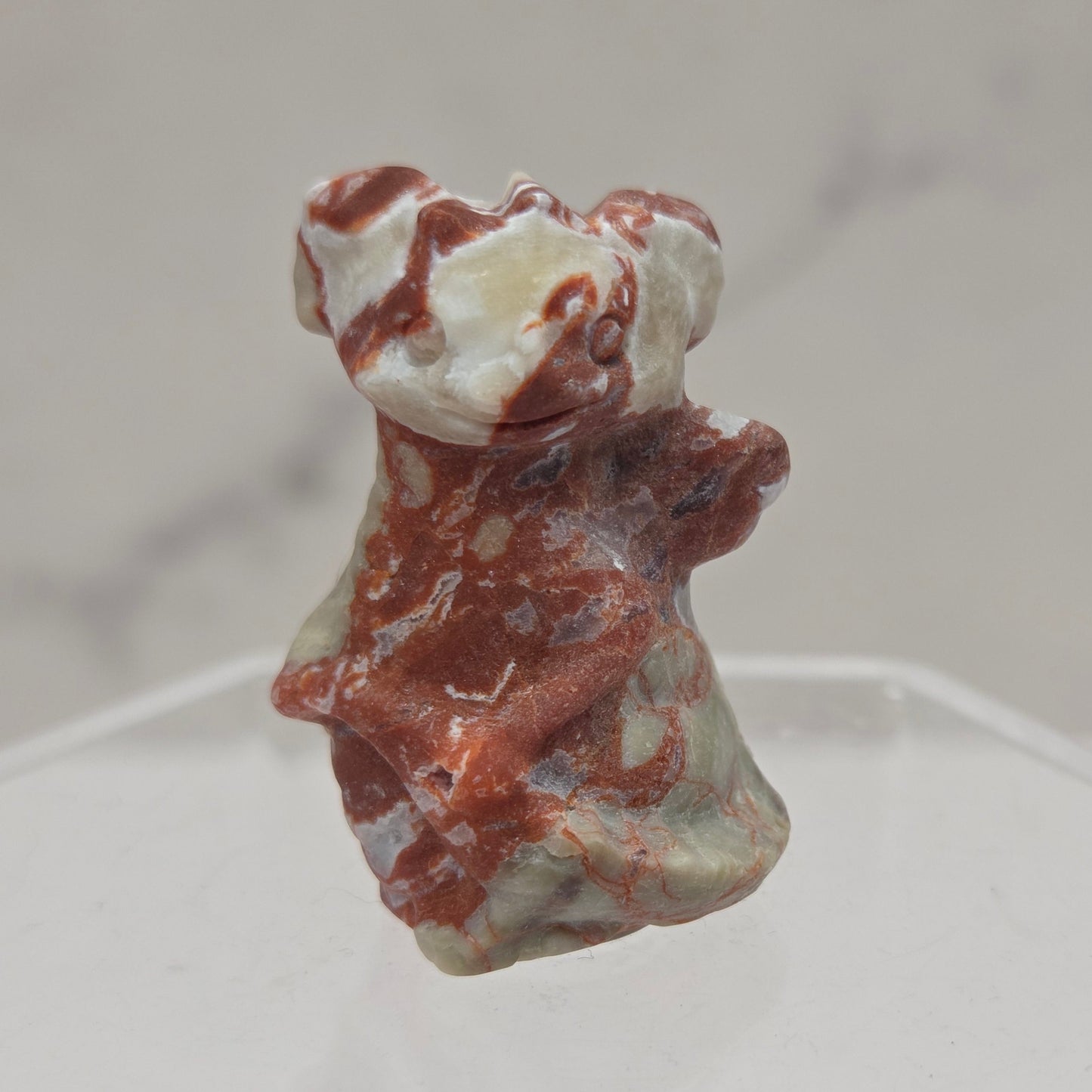 multi-colored Money Agate dragon carving on a white background