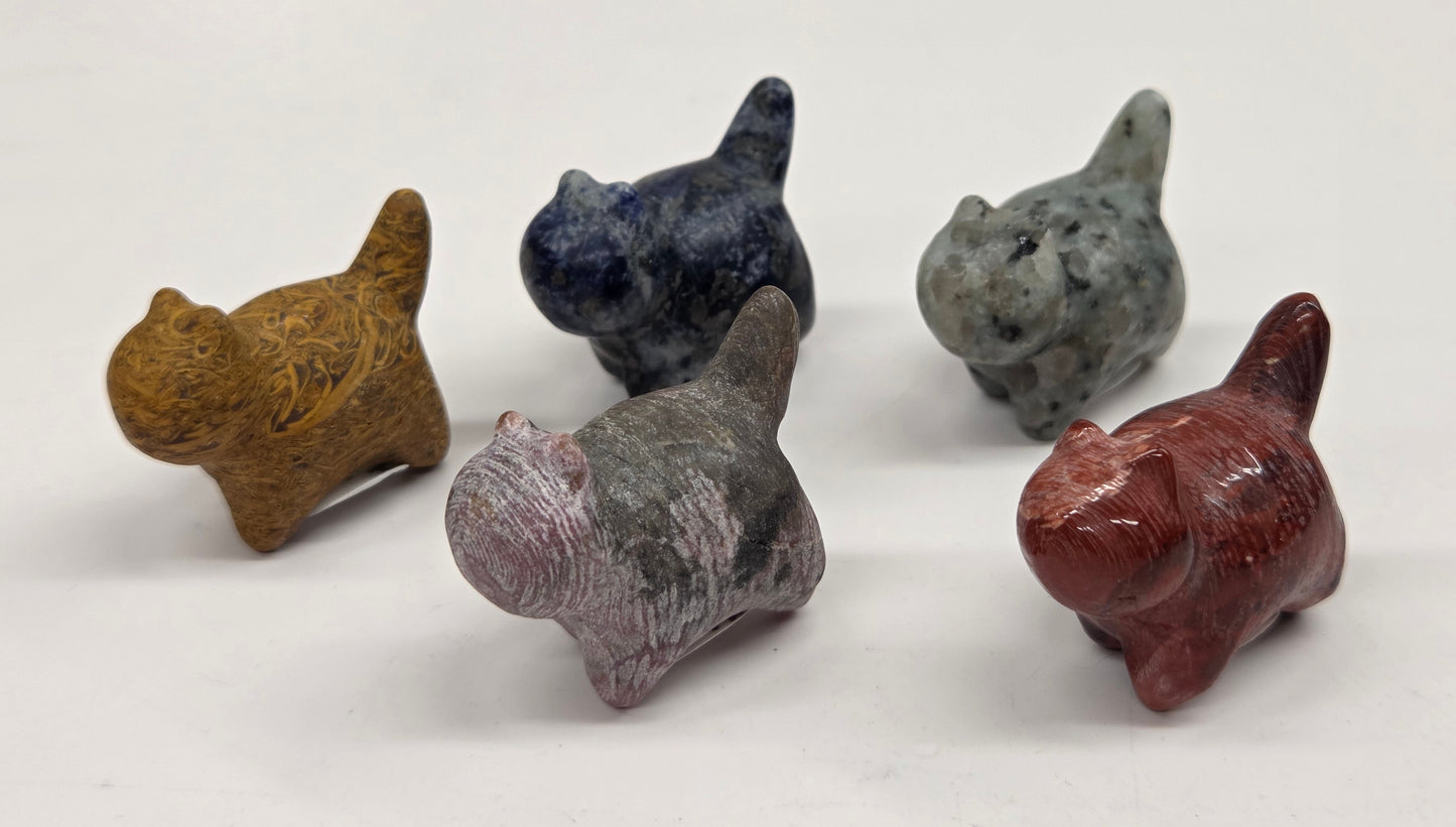 Five small stone animal figurines on a white background
