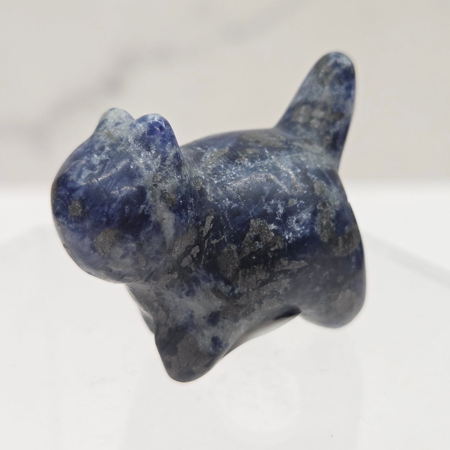 Blue stone cat figurine on a white background