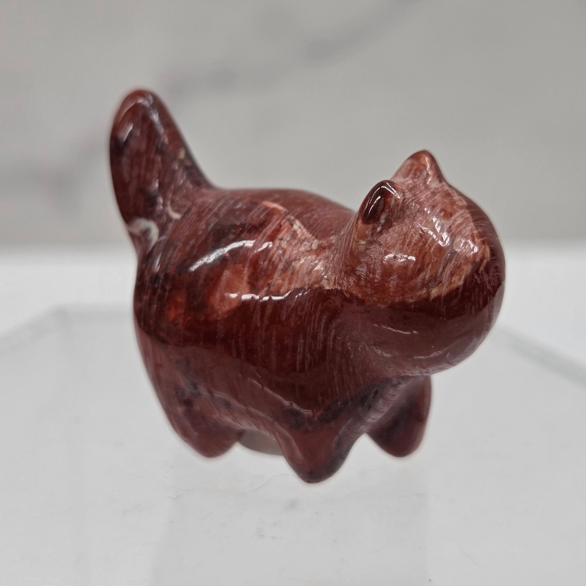 Brown stone sculpture of a cat on a white background
