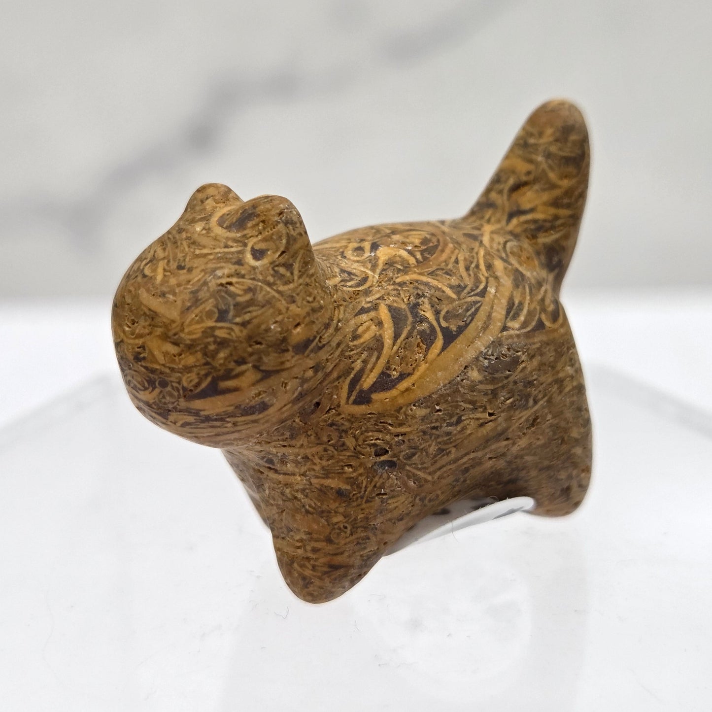 Decorative cat-shaped object with intricate patterns on a white background