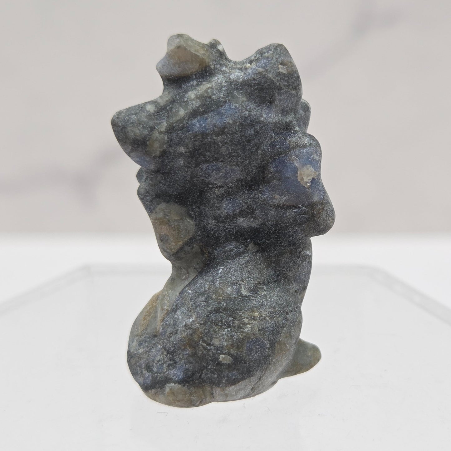 Small stone sculpture resembling a cat on a white background