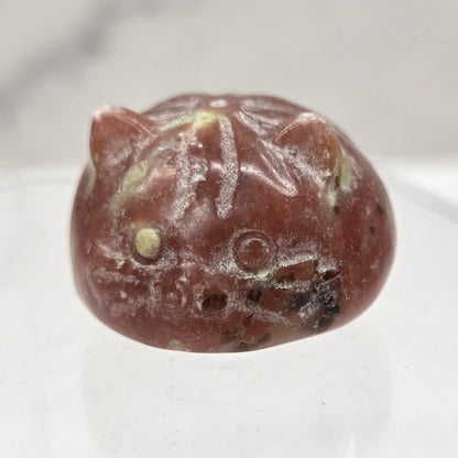 Carved stone object resembling a cat on a white background