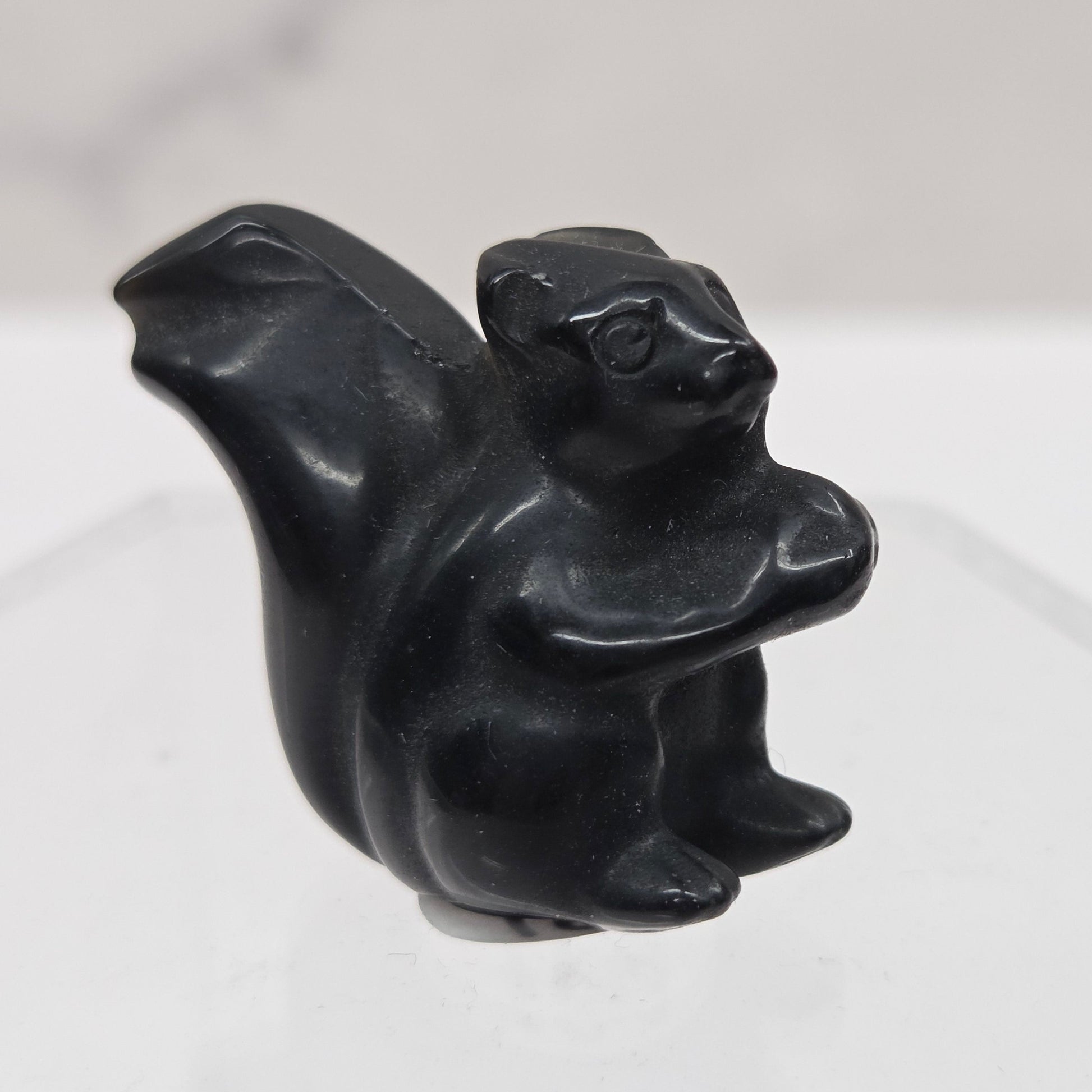 Black stone carving of a stylized animal on a white background