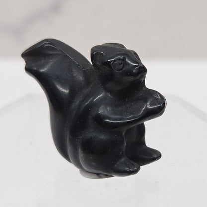 Black stone carving of a stylized animal on a white background