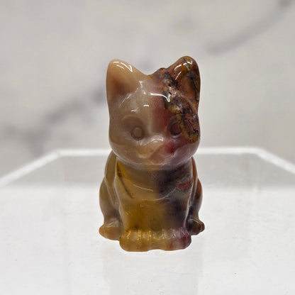 Mookaite cat carving in red, yellow, and brown on a white background