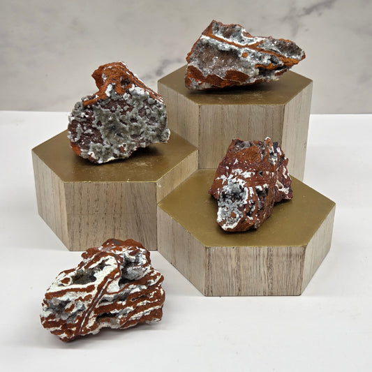 Crystal specimens on a wooden stand against a neutral background