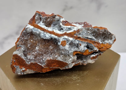 Mineral sample on a wooden stand with a marble background