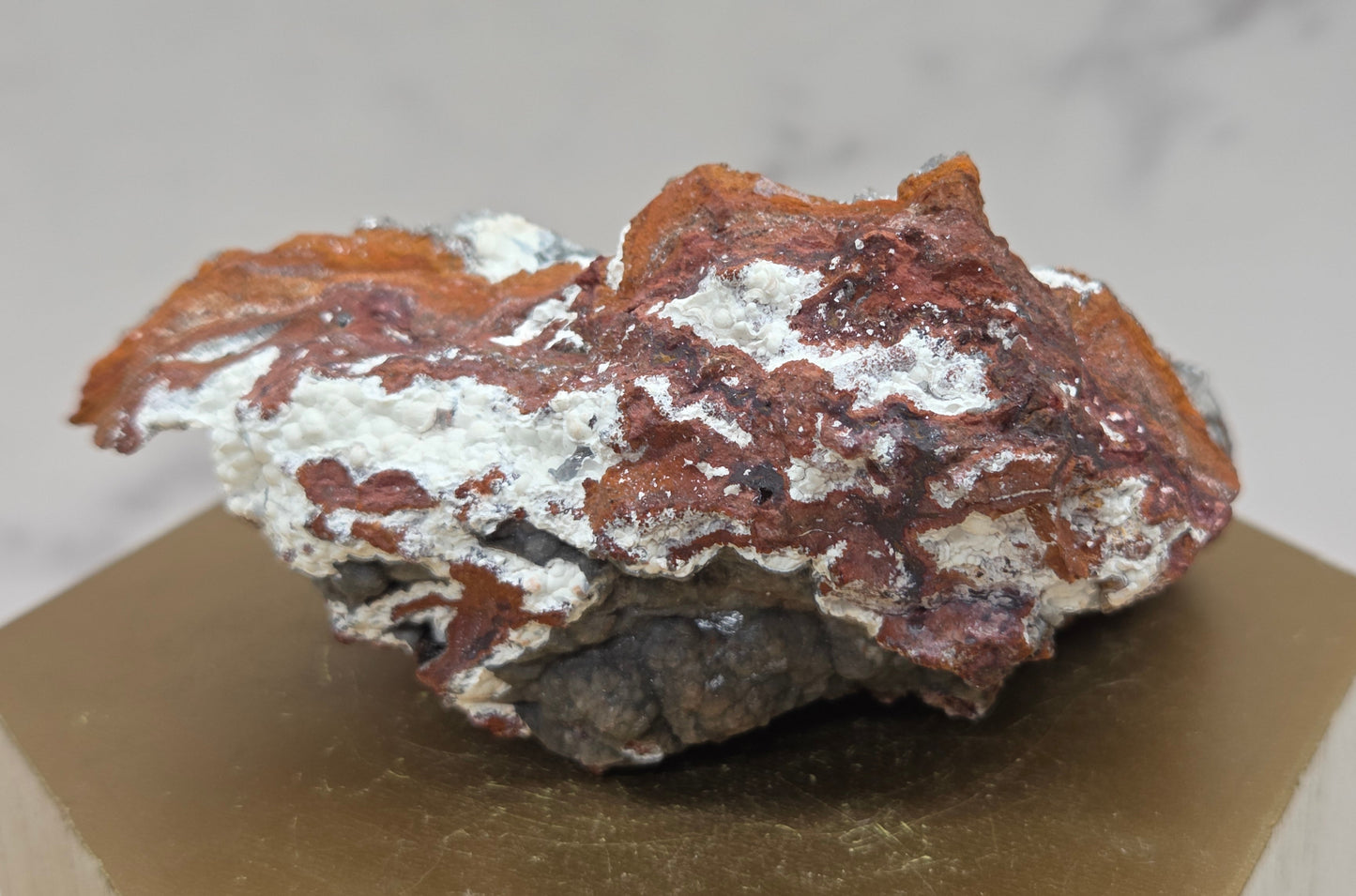 Mineral sample on a hexagonal base with a neutral background