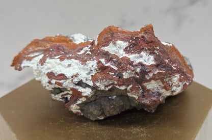 Mineral sample on a hexagonal base with a neutral background