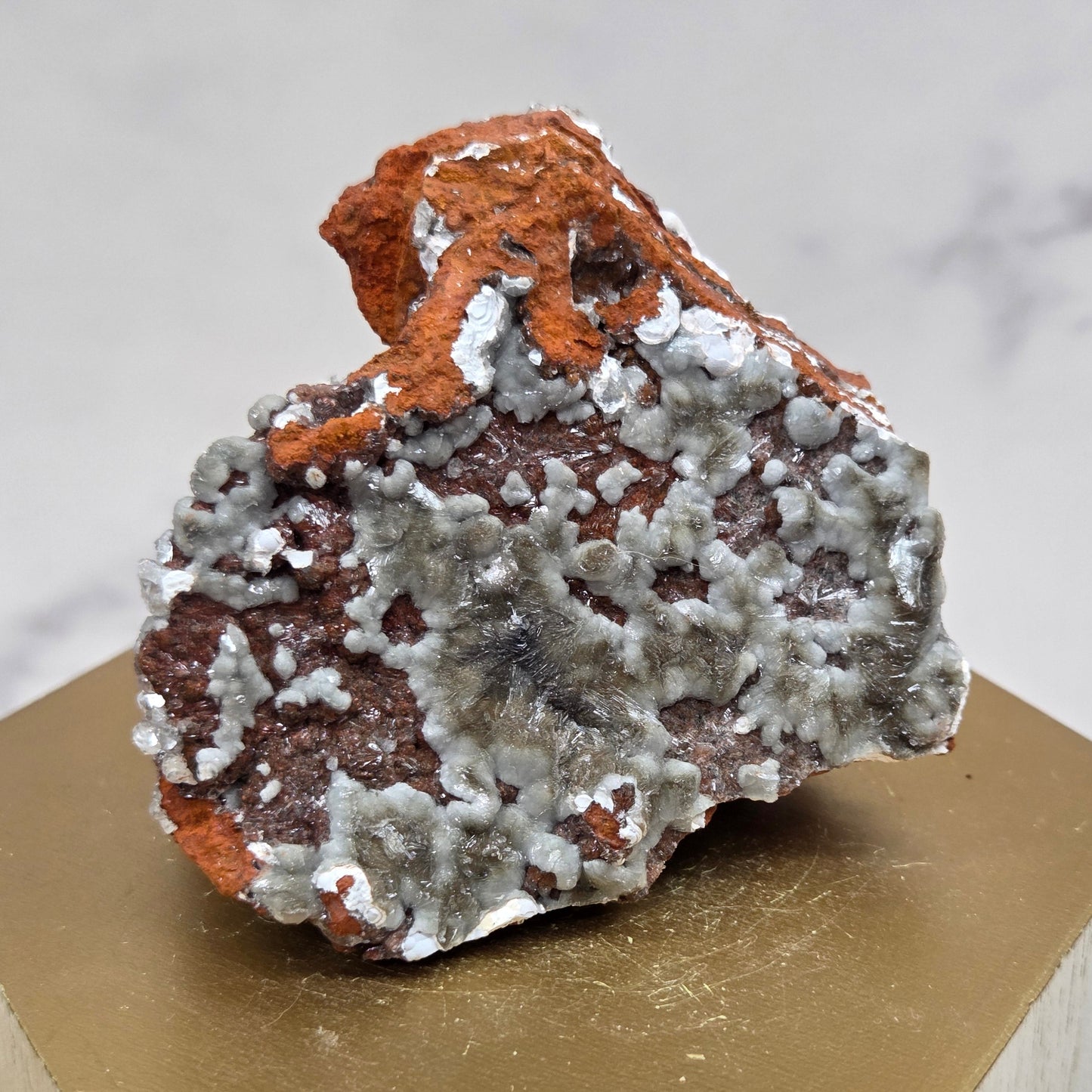 Mineral sample on a wooden stand with a marble background