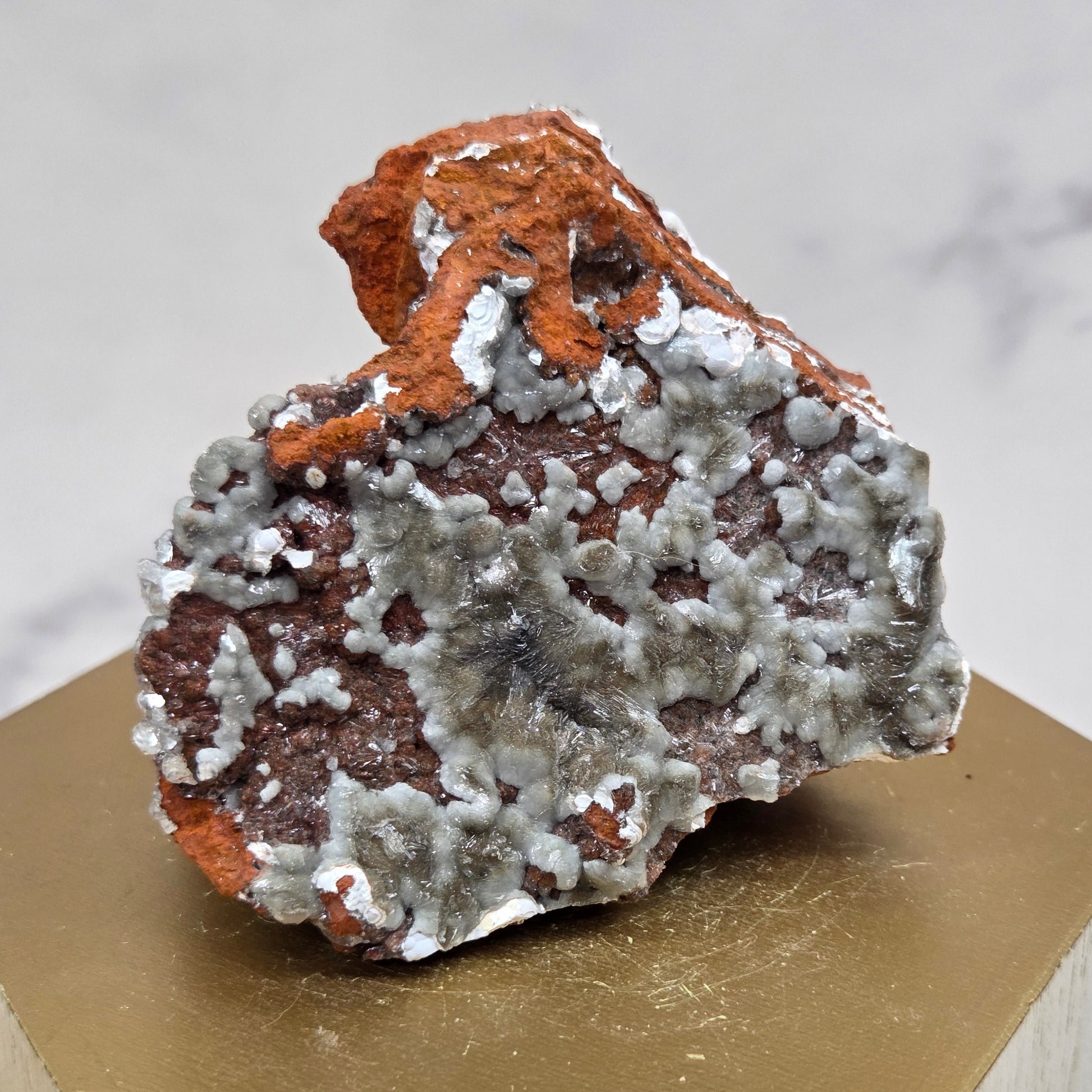 Mineral sample on a wooden stand with a marble background