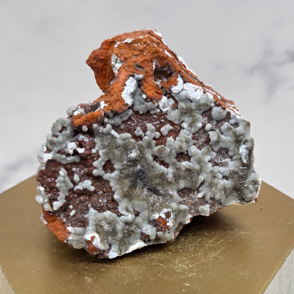 Mineral sample on a wooden stand with a marble background