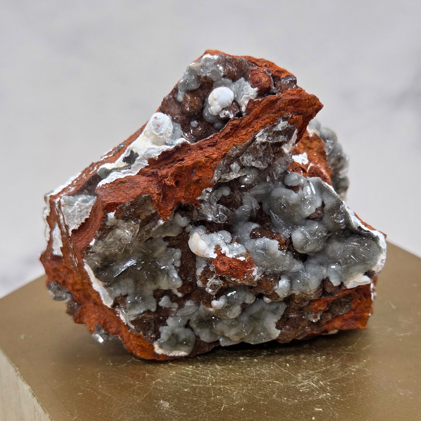 Mineral sample on a wooden stand against a neutral background