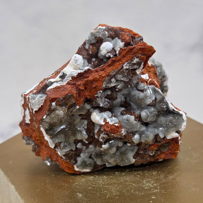 Mineral sample on a wooden stand against a neutral background