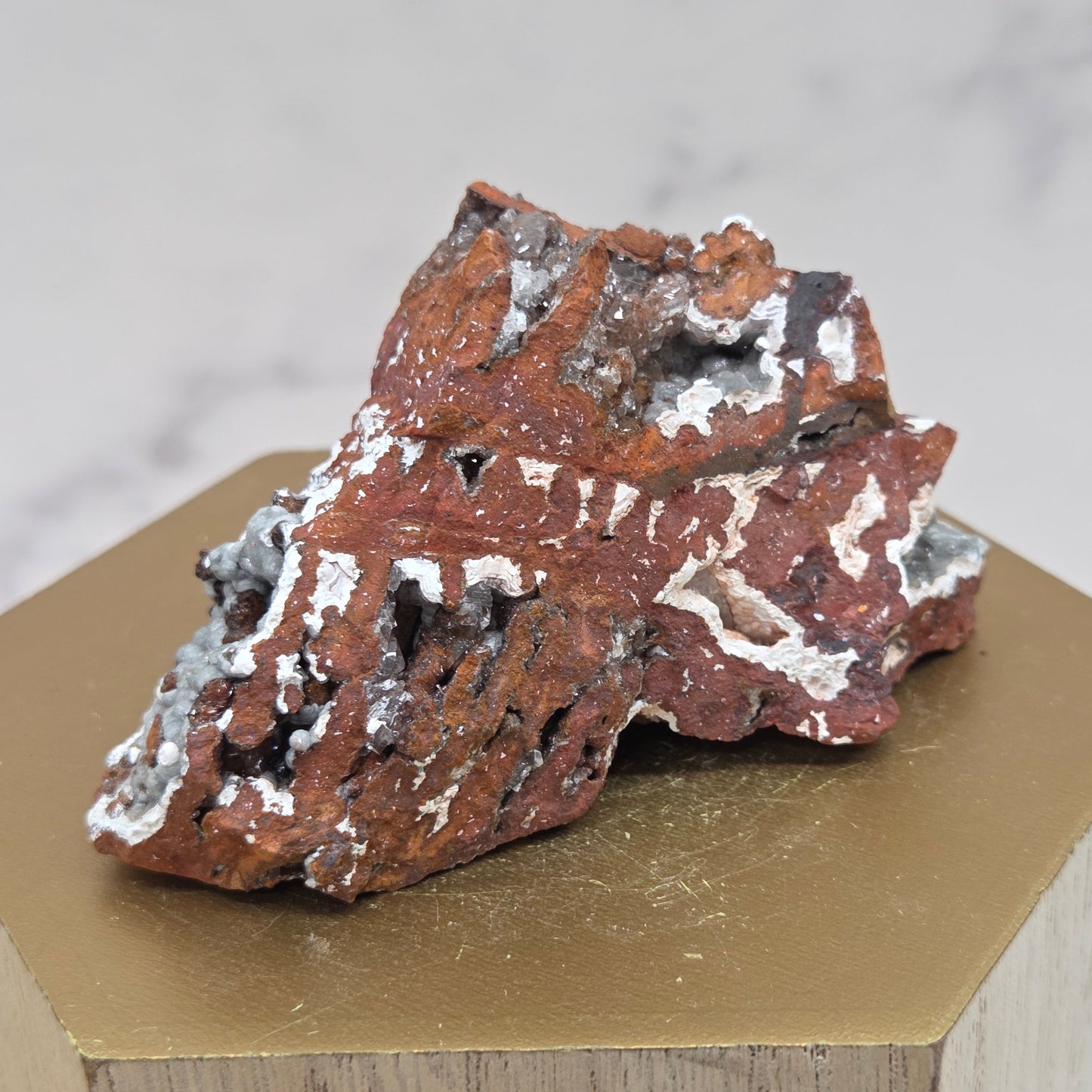 Mineral sample on a wooden stand with a neutral background