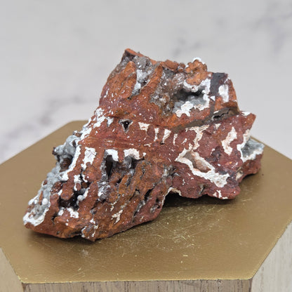 Mineral sample on a wooden stand with a neutral background