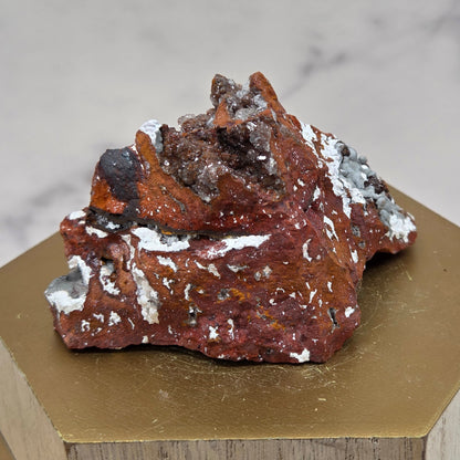 Mineral sample on a wooden stand with a marble background