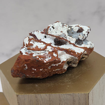 Mineral sample on a wooden stand against a neutral background