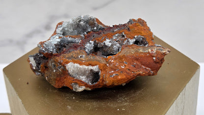 Mineral sample on a wooden stand against a marble background