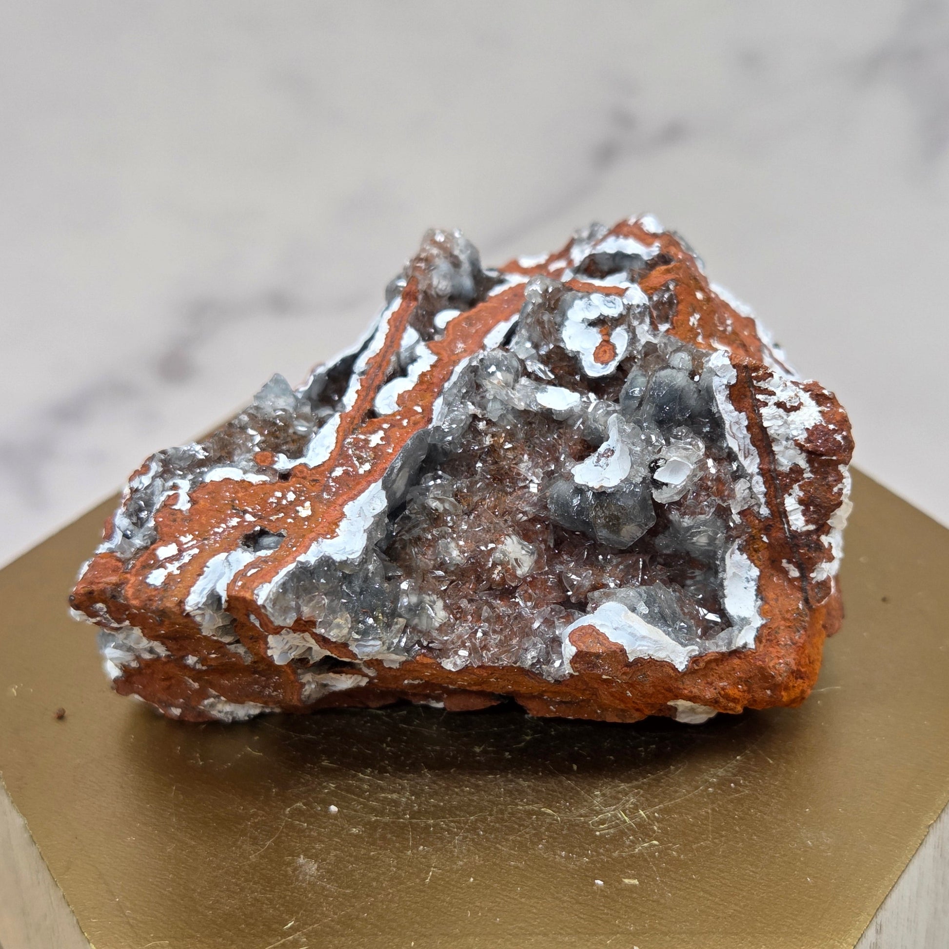 Mineral sample on a wooden stand with a marble background