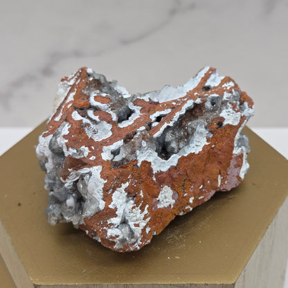 Mineral sample on a wooden stand against a marble background