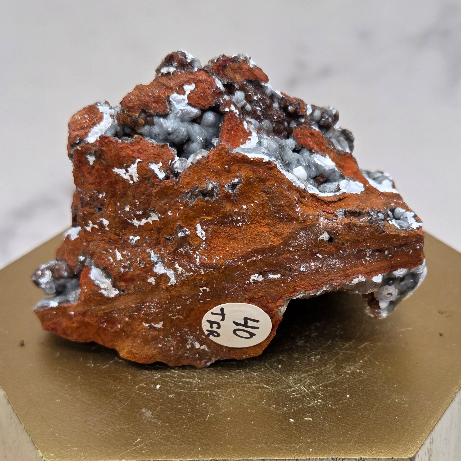 Mineral sample with a label on a wooden stand against a neutral background