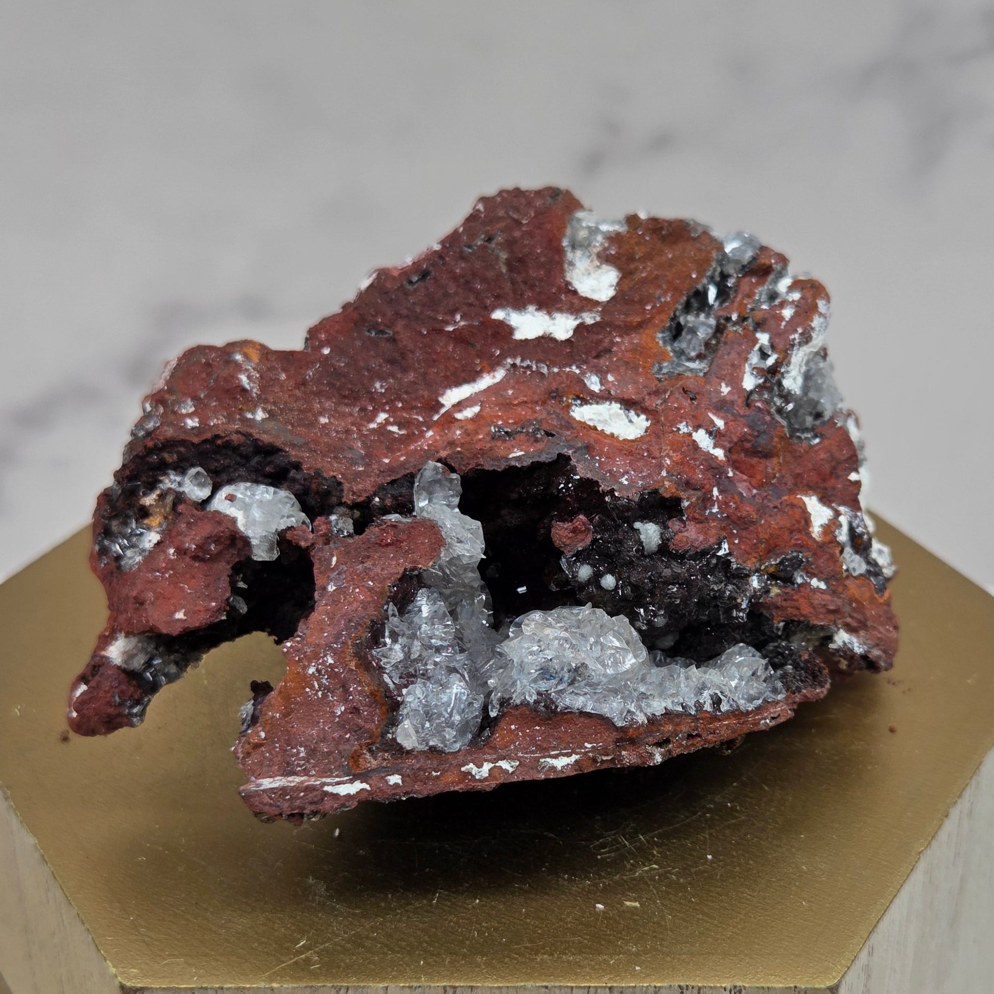 Mineral sample on a wooden stand with a marble background
