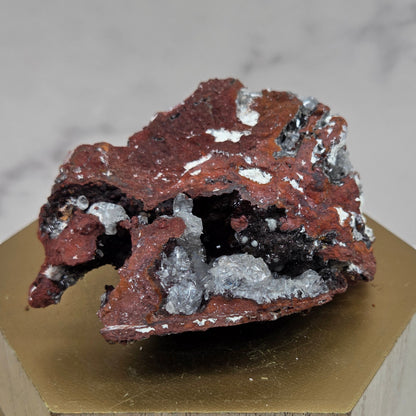 Mineral sample on a wooden stand with a marble background