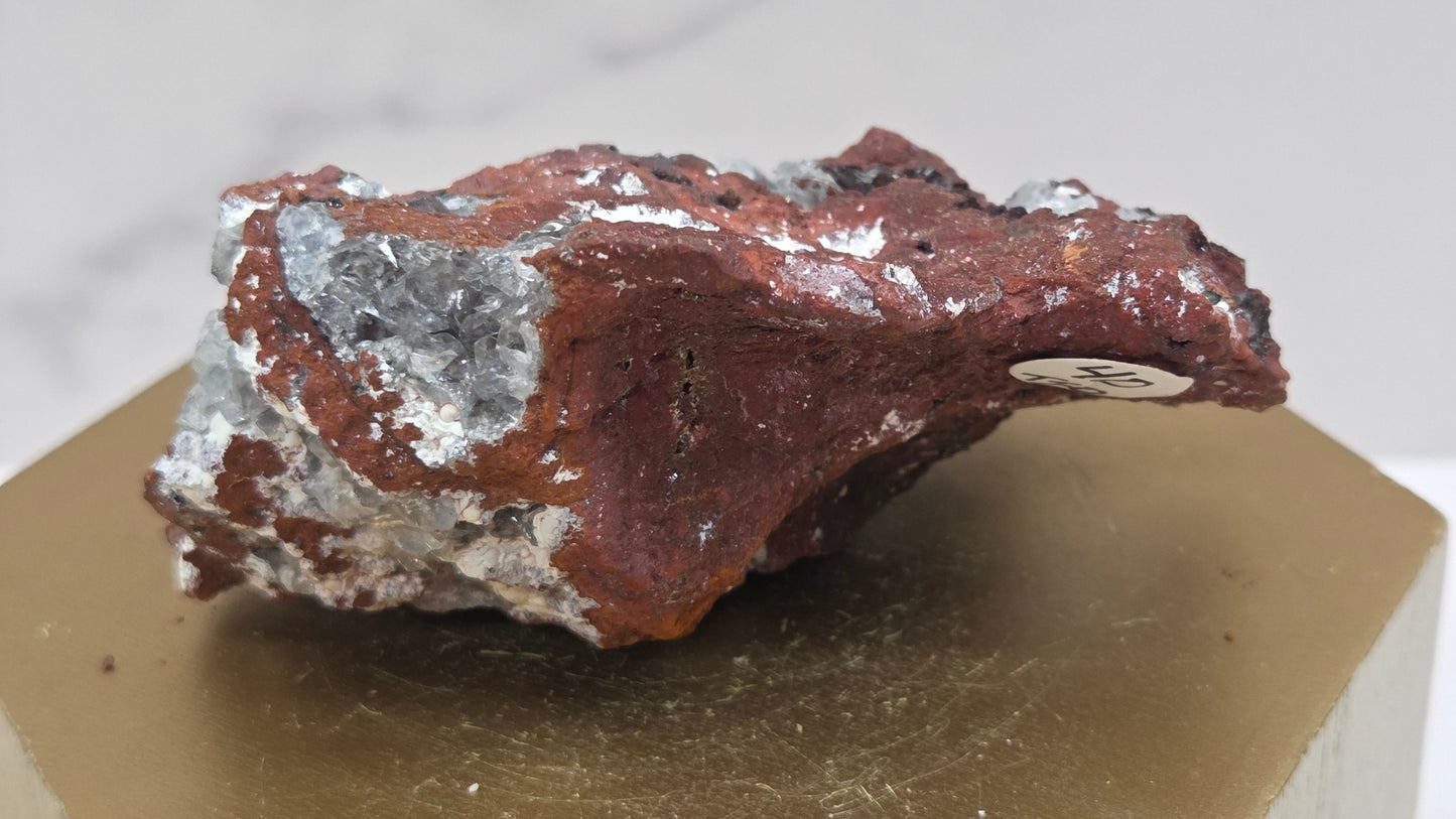 Mineral sample on a wooden stand with a white background