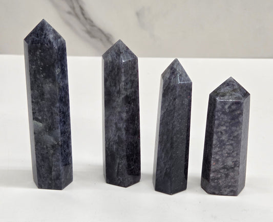 Set of four blue-gray crystal points on a neutral background