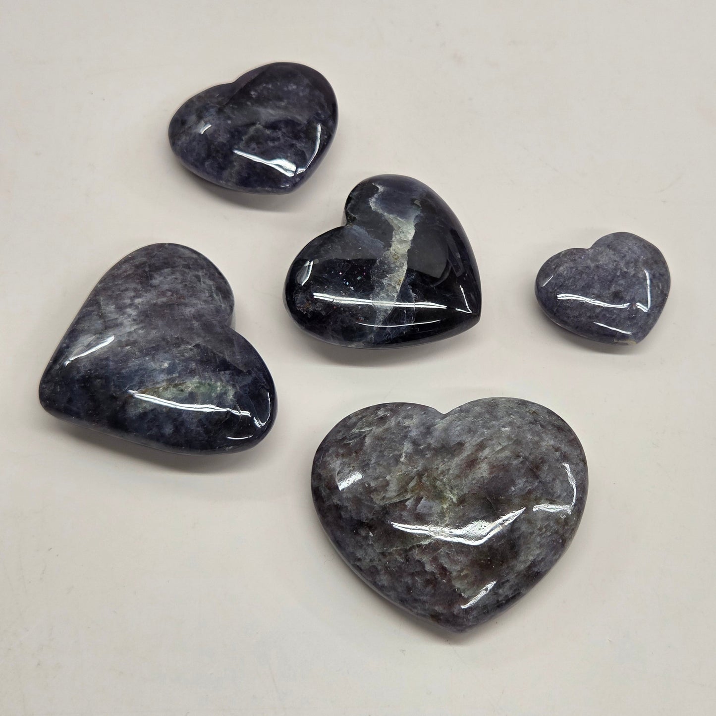 Five heart-shaped stones on a light gray background