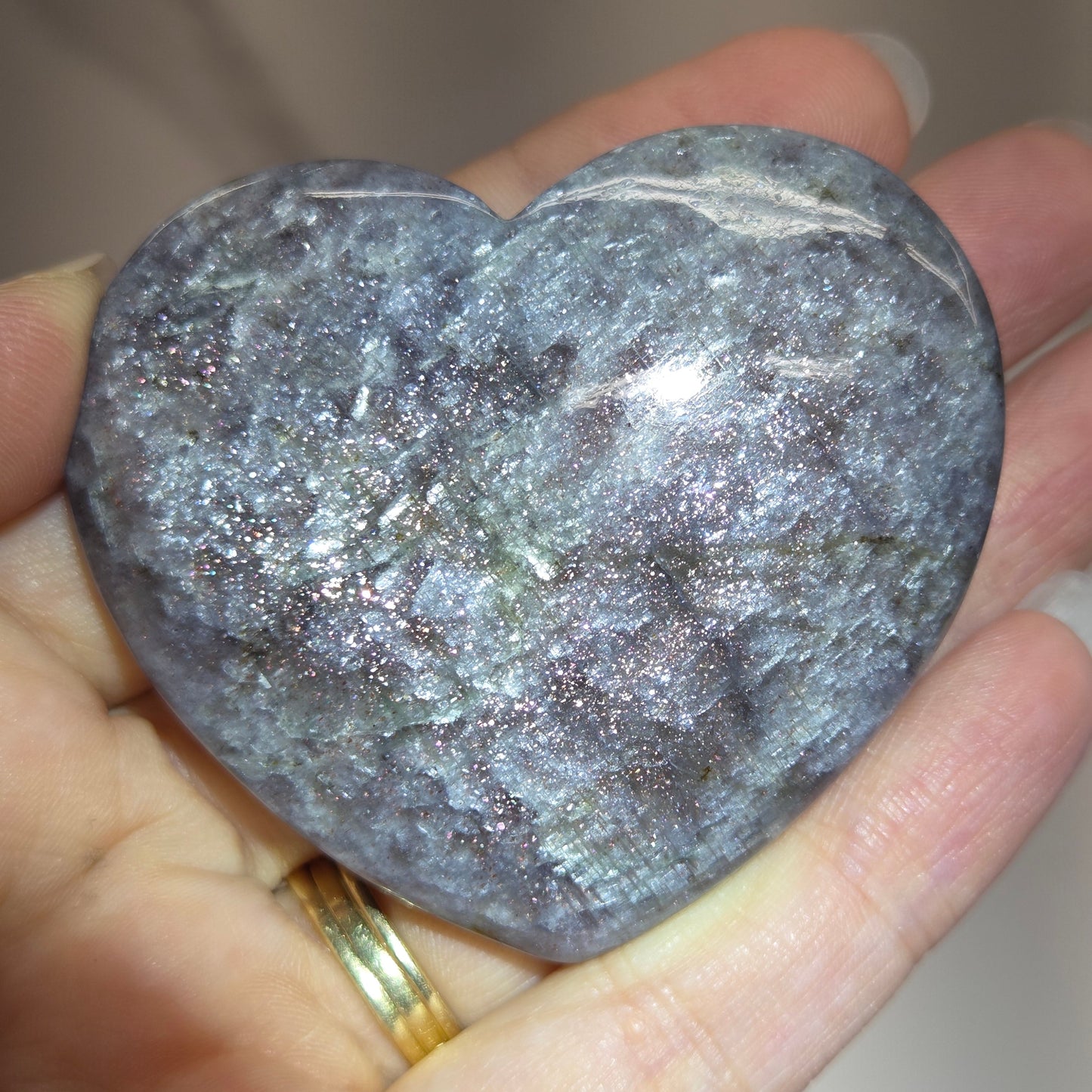 Hand holding a large purple heart shaped crystal 