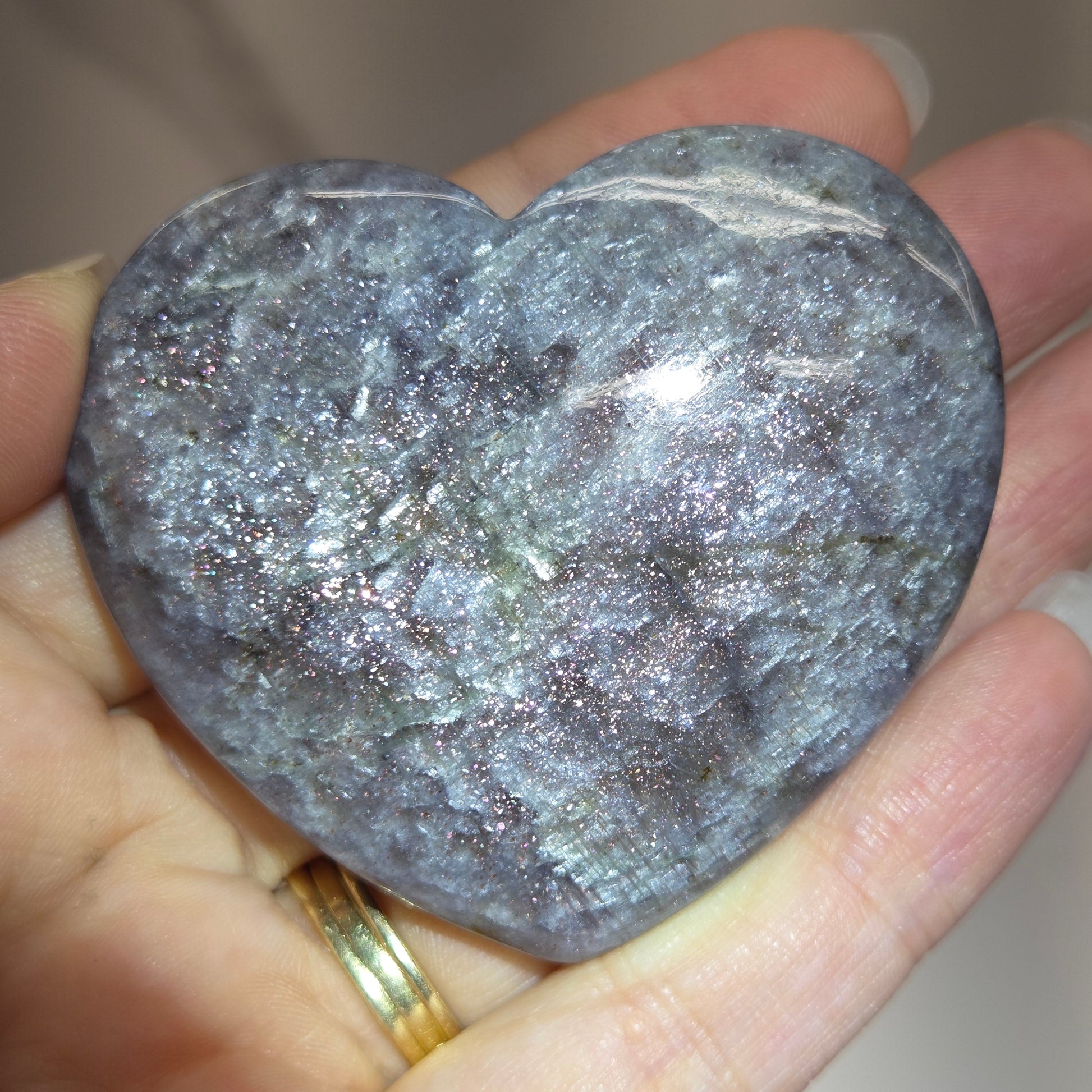 Hand holding a large purple heart shaped crystal 