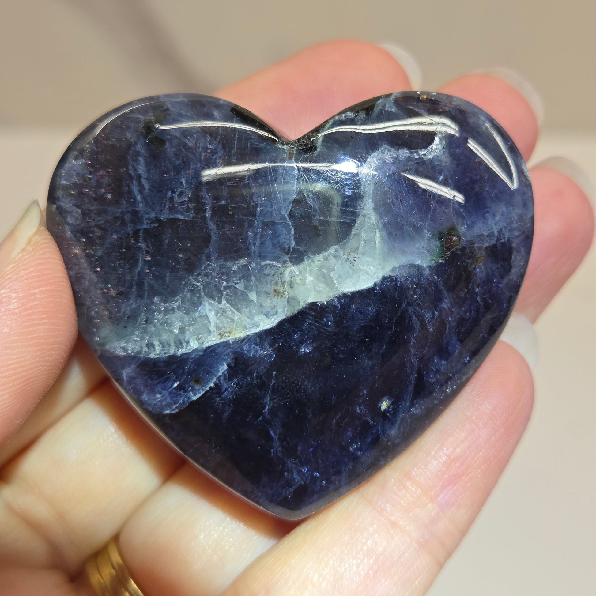 Hand holding a large purple heart shaped crystal 