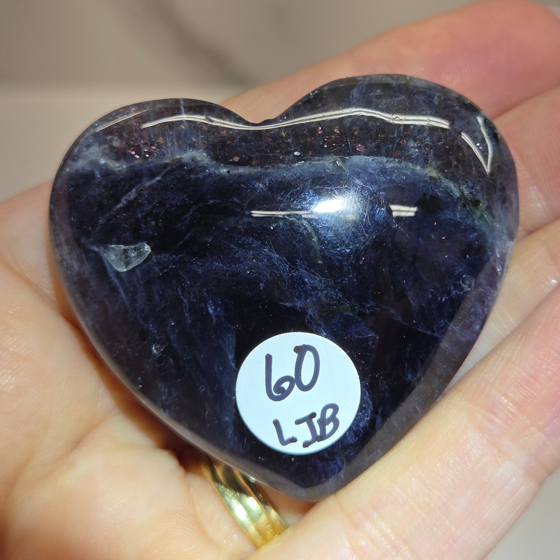 Hand holding a large purple heart shaped crystal 