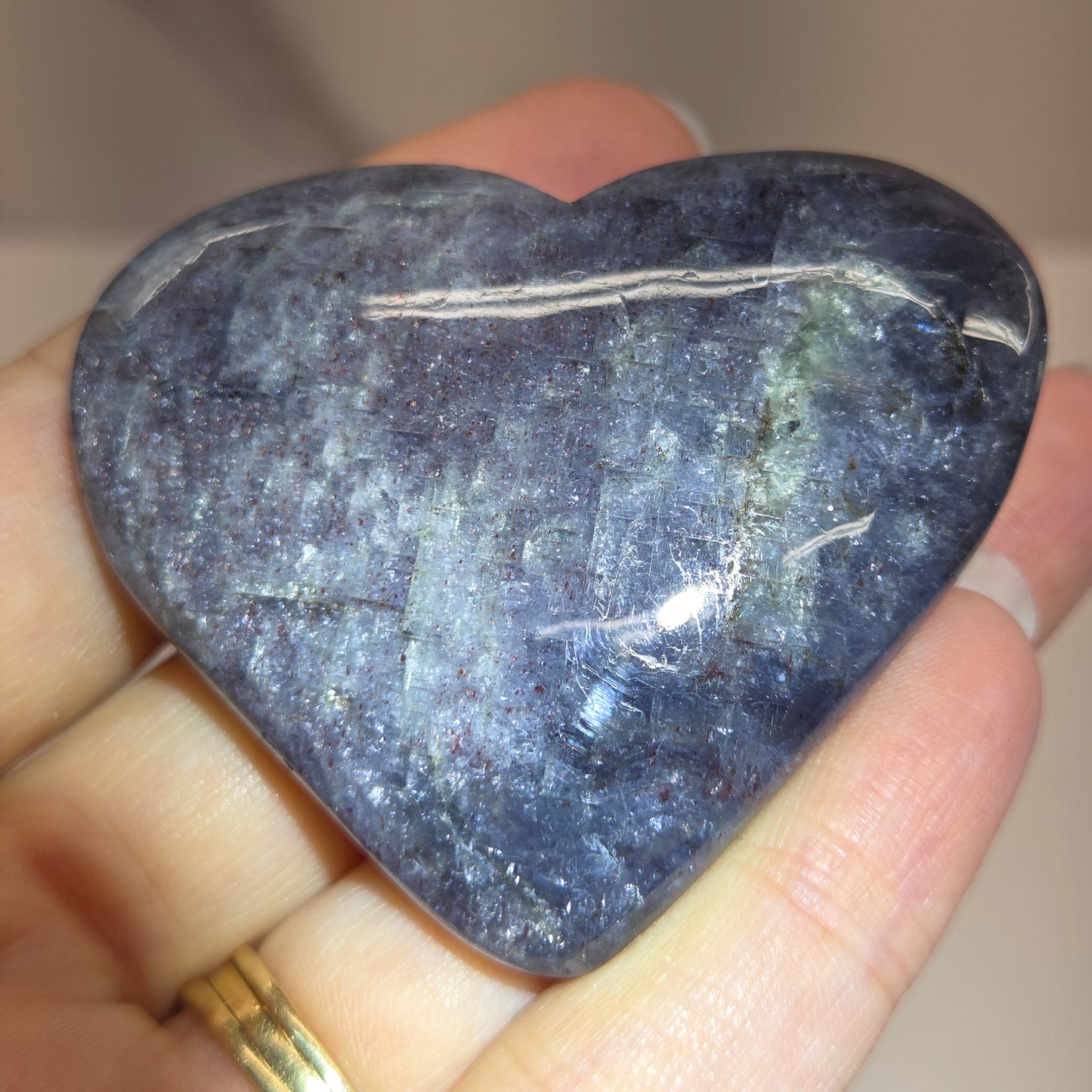 Hand holding a large purple heart shaped crystal 