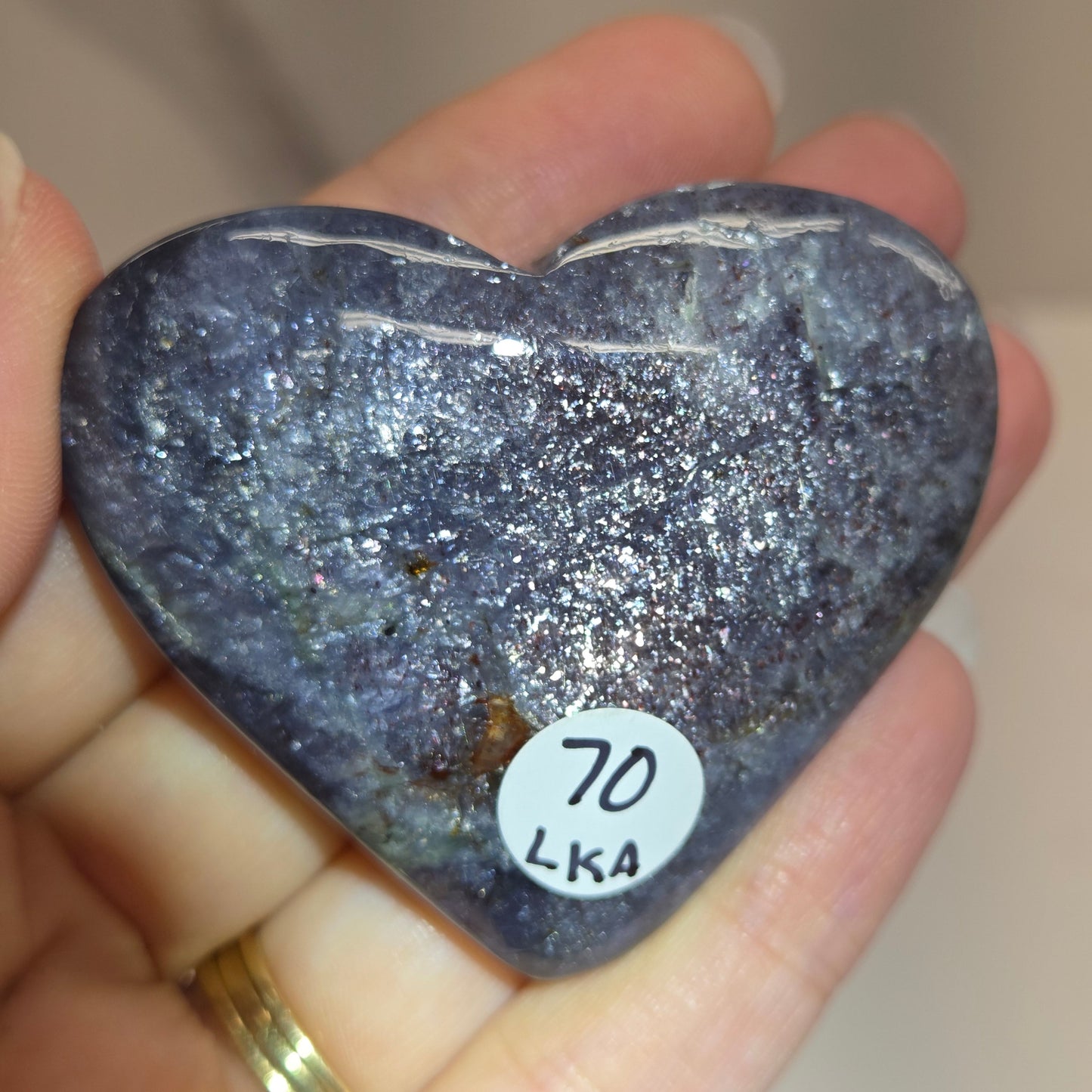 Hand holding a large purple heart shaped crystal 