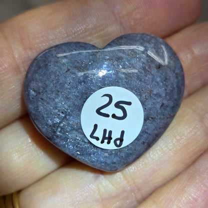 Hand holding a large purple heart shaped crystal 