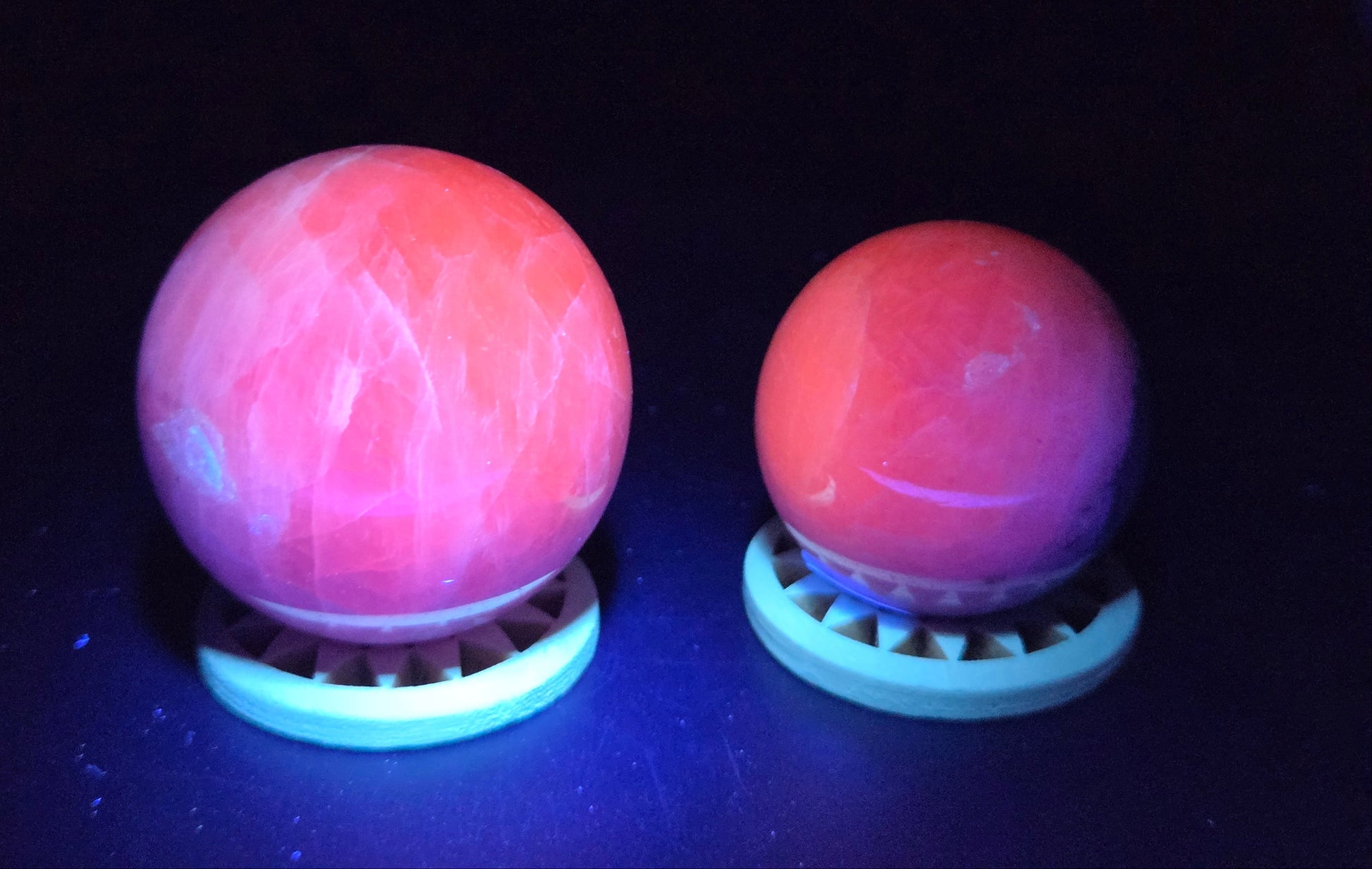 purple and white crystal spheres under UV light against a neutral background
