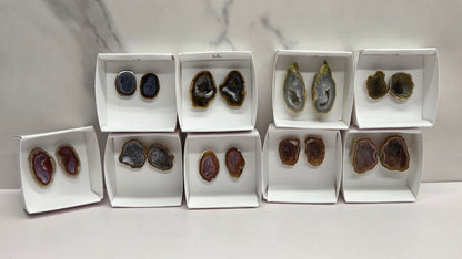 Set of geode crystals in small white boxes on a marble background