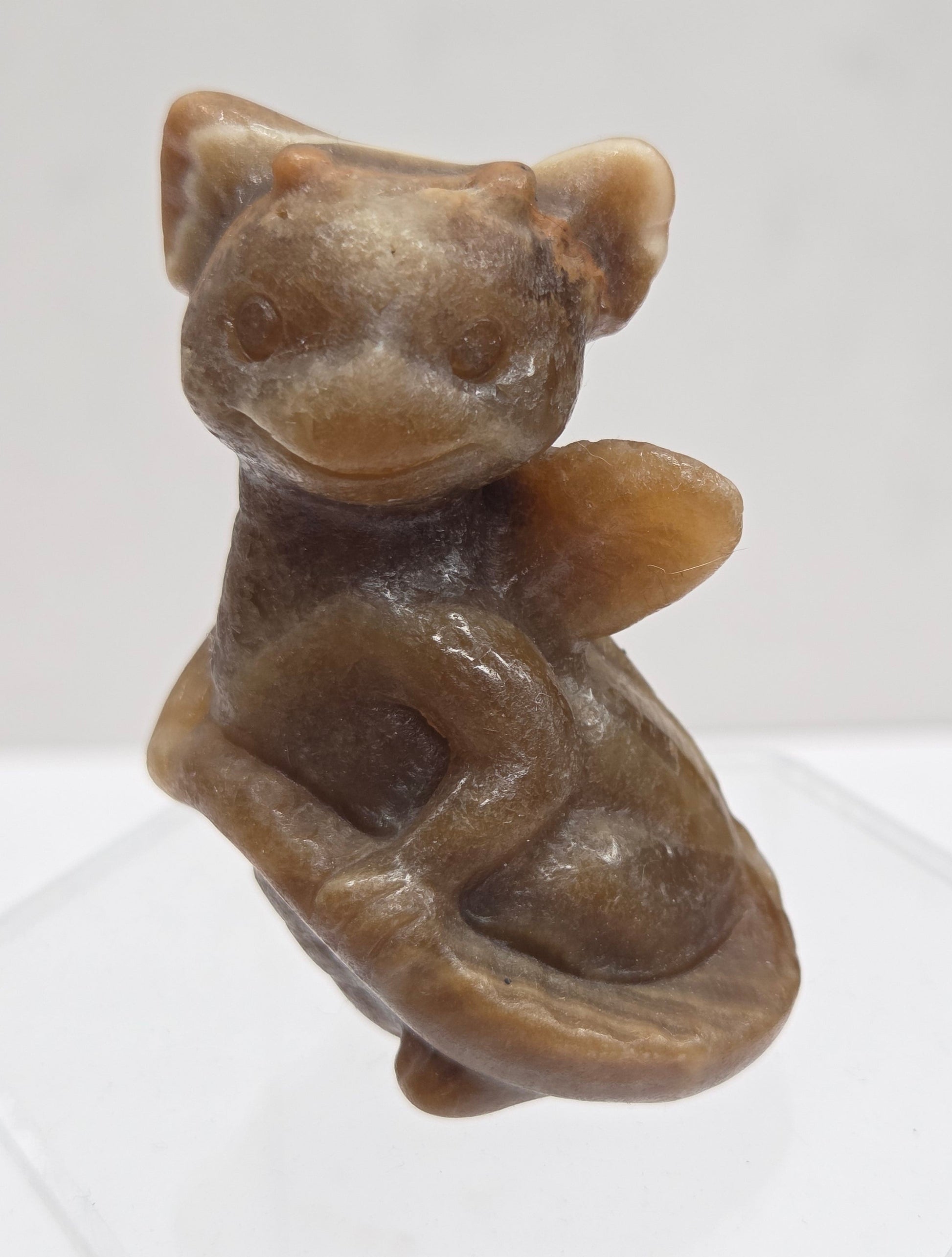 Brown calcite sculpture of a dragon on a white background