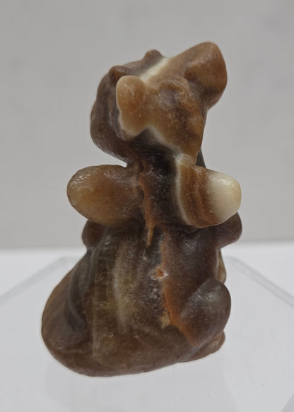 Brown calcite sculpture of a dragon on a white background