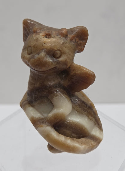 Brown calcite sculpture of a dragon on a white background