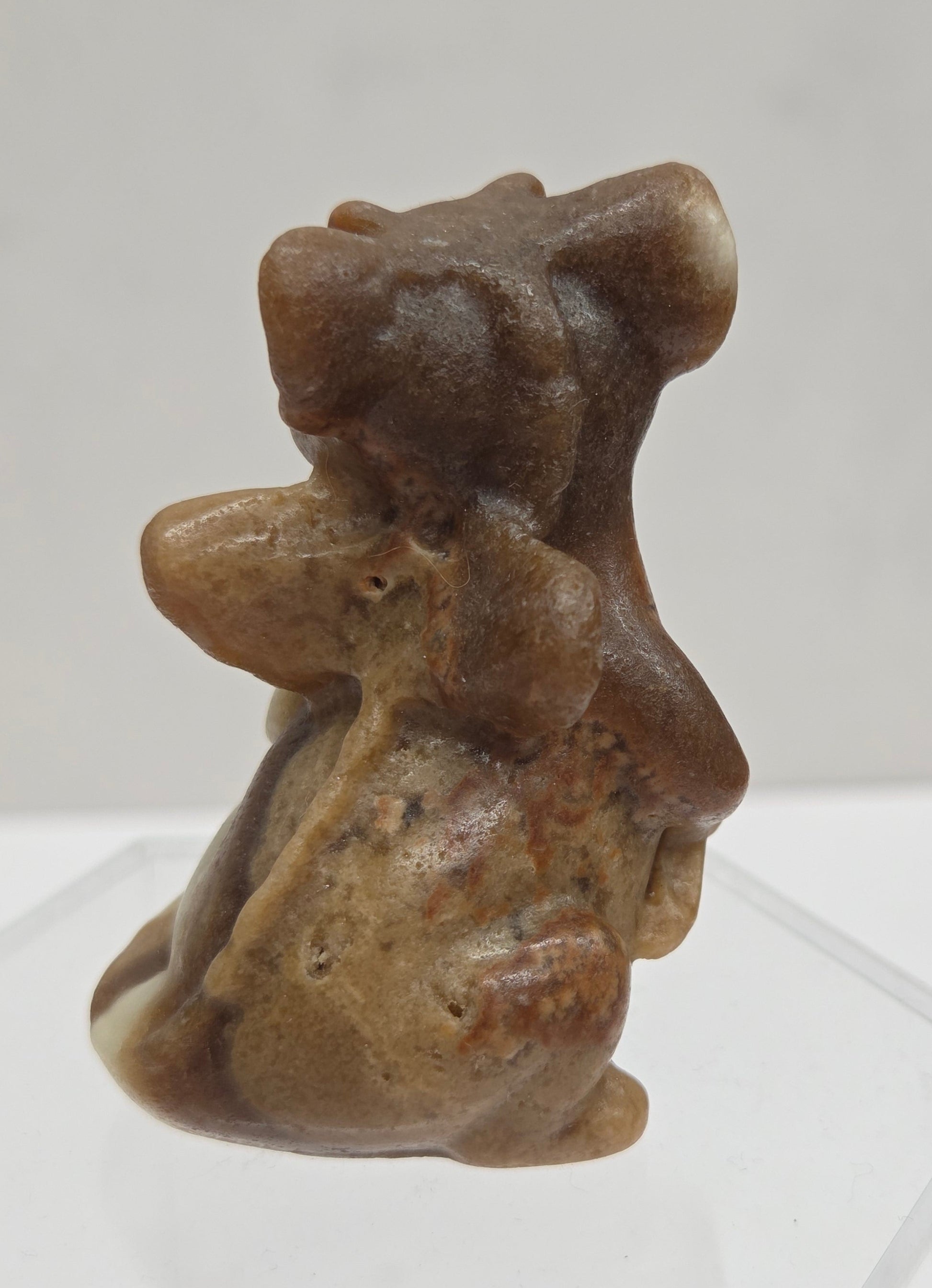 Brown calcite sculpture of a dragon on a white background