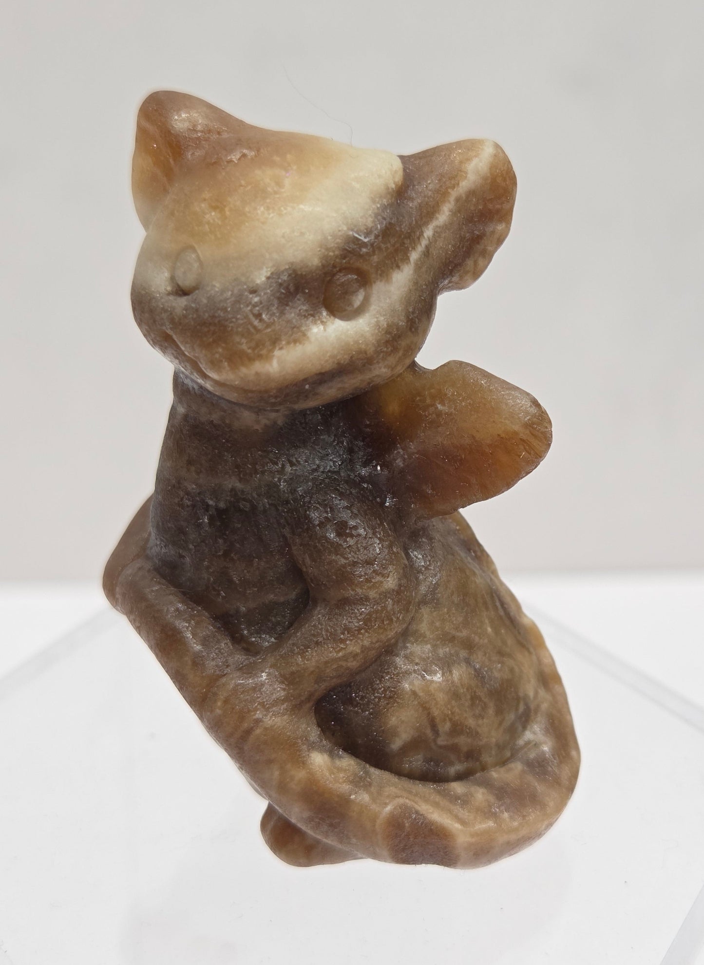 Brown calcite sculpture of a dragon on a white background
