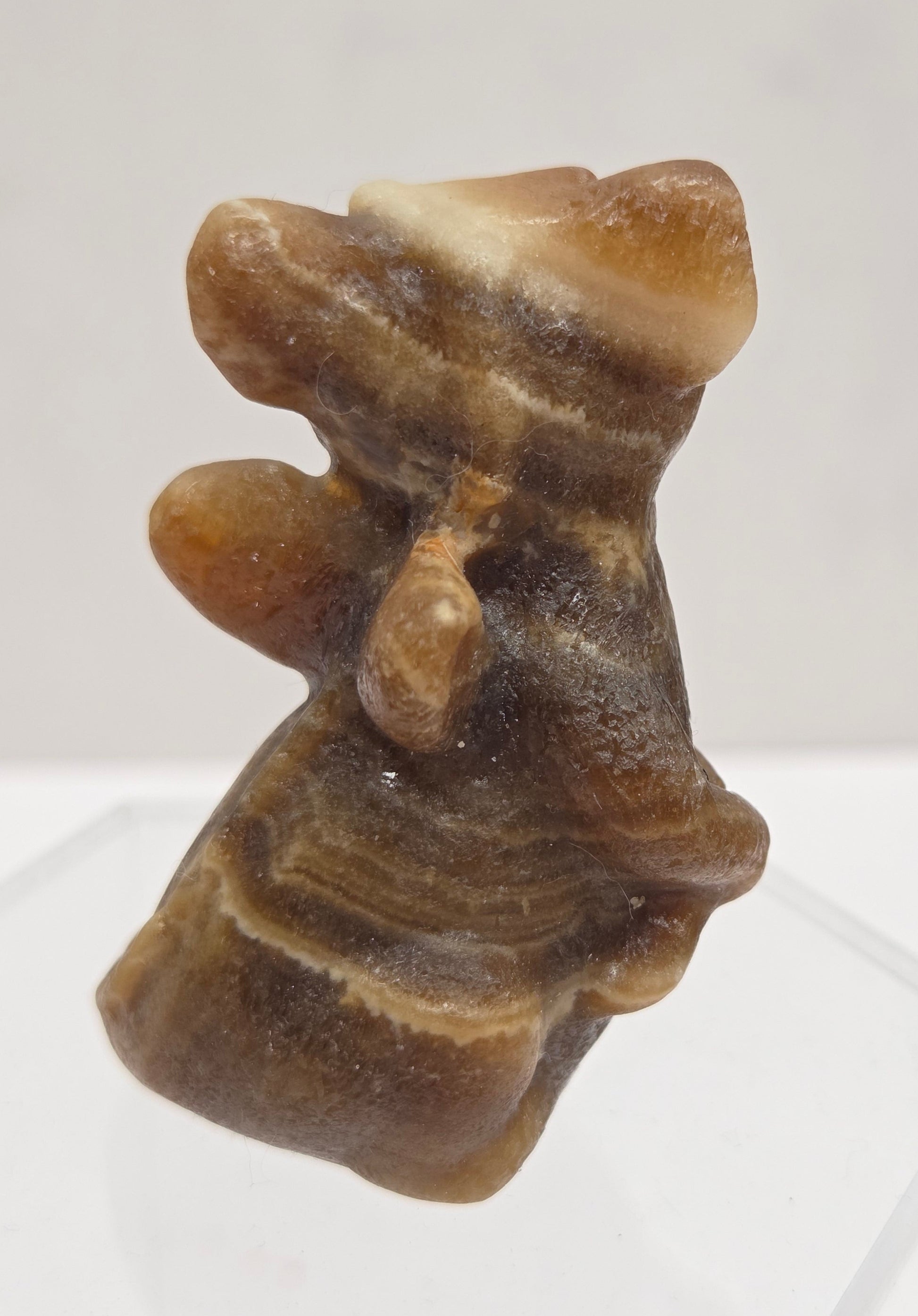 Brown calcite sculpture of a dragon on a white background