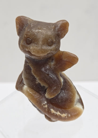 Brown calcite sculpture of a dragon on a white background